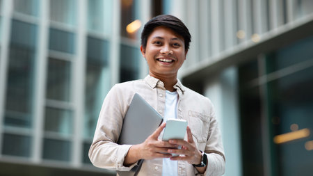 Happy asian man manager going to office, using phone