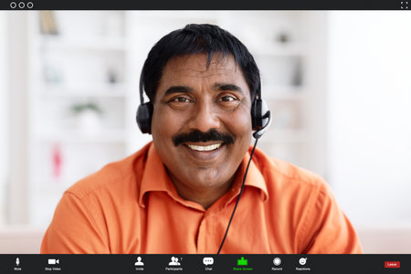 Smiling middle aged indian man in headphones smiling at camera