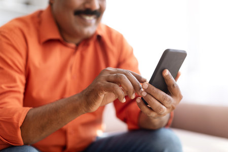 Home Comforts: Indian Man Browsing on Smartphoneの写真素材