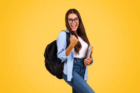 Cheerful pretty smart young student woman with backpack in glasses, enjoy successの写真素材