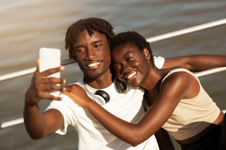 Happy Black Millennial Couple Taking Selfie On Smartphone While Doing Sport Outdoorsの写真素材