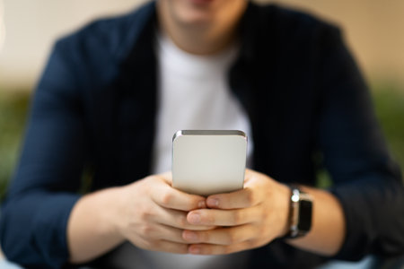 Young caucasian guy typing on smartphone focus on, enjoy chat in social networks with smartwatch