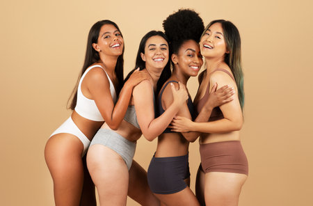 Four joyful women in underwear, celebrating diversity and beautyの写真素材