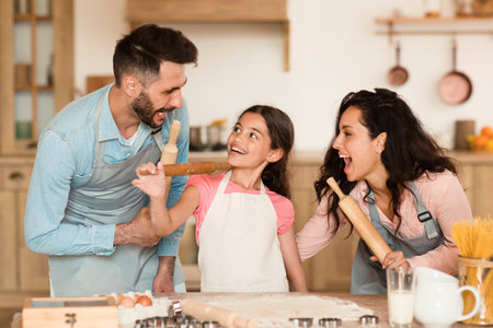 Family fun with rolling pins in kitchenの写真素材