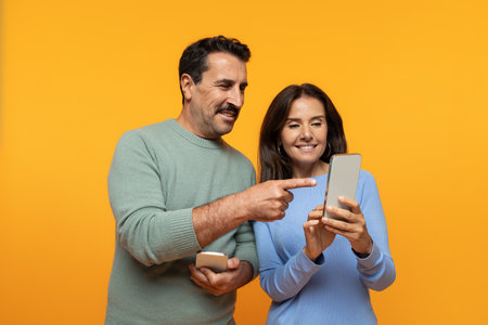 Positive old european family watch video on phone, point finger at smartphoneの写真素材
