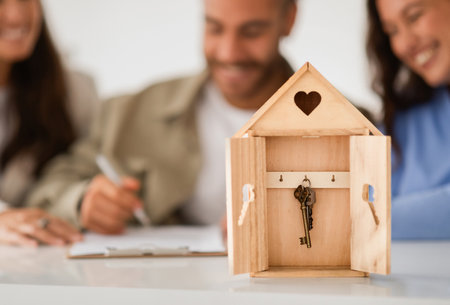 Wooden house shaped box with key inside over married coupleの写真素材