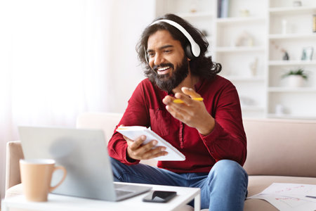 Positive millennial indian man have online training, using laptopの写真素材