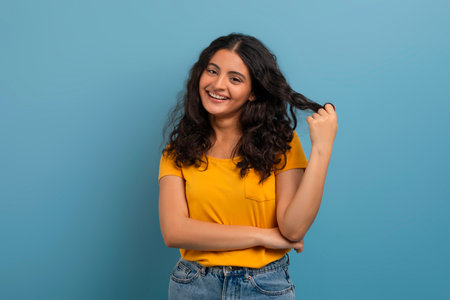Cute young indian woman playing with her curly hair
