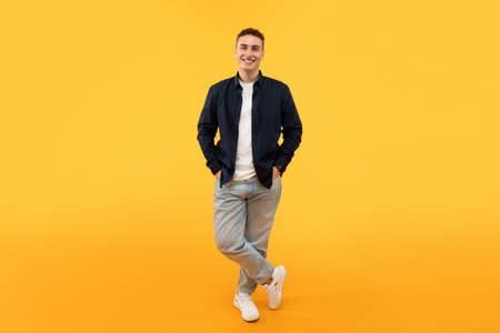 Stylish young guy posing isolated on yellow background