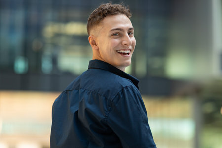 Positive surprised attractive millennial caucasian man student in casual look back in city, walk,...