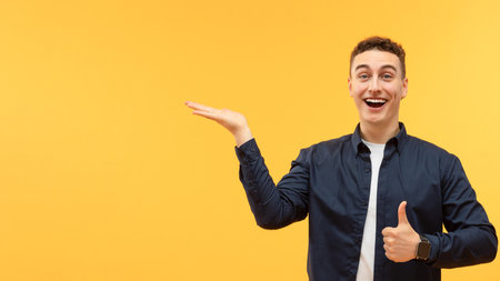Excited young guy pointing at blank space