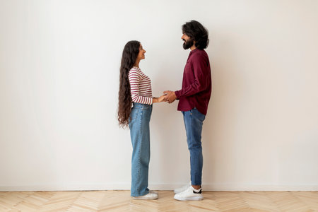 Happy young indian man and woman posing over white wallの写真素材