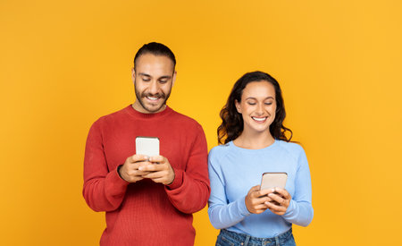 Portrait of cheerful couple holding their smartphones and playing game