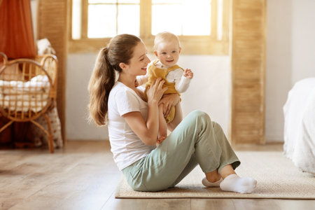Cheerful Young Mom Holding Baby In Arms Smilingの写真素材