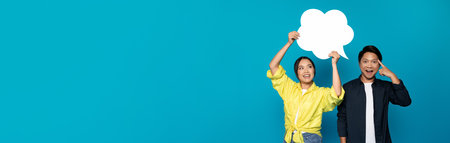 Smiling young asian lady hold abstract cloud with copy space, guy got idea, point finger at headの写真素材