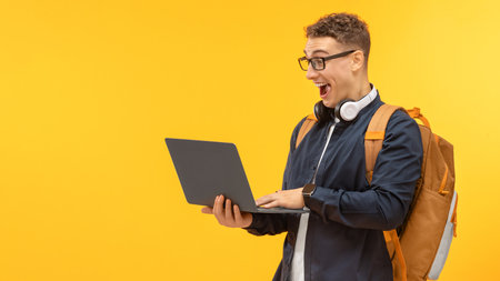 Positive guy student with backpack and laptop, copy space