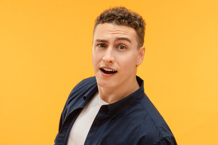Closeup of young guy looking at camera, raising brow