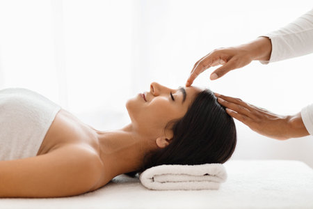 Young indian woman getting head massage at spaの写真素材