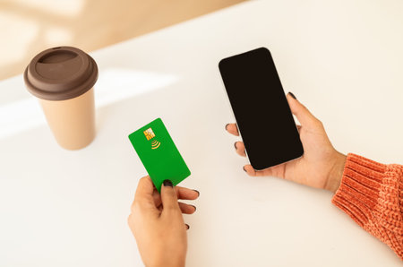 Hands of young latin woman enjoy shopping on smartphone with empty screen, credit card