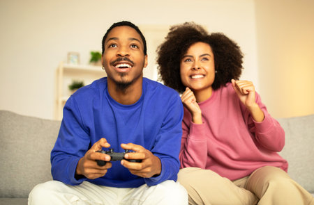 African American couple enjoying gaming session with digital gamepad indoorの写真素材