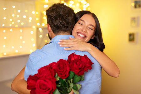 Joyful woman embracing man with bouquet of rosesの写真素材