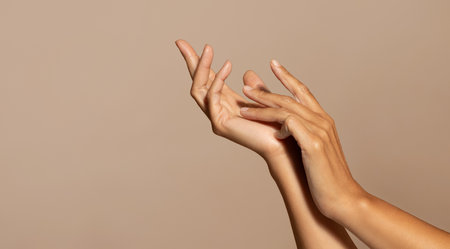 Hands of caucasian senior woman enjoy skin care, isolated on beige studio background, close upの写真素材