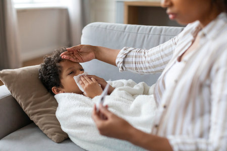 Seasonal Flu. Worried Black Mom Checking Temperature Of Ill Son At Home