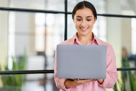 Happy young arab lady manager typing on laptop, enjoy project, planning startupの写真素材