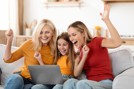 Emotional grandmother, mother and daughter using laptop at home