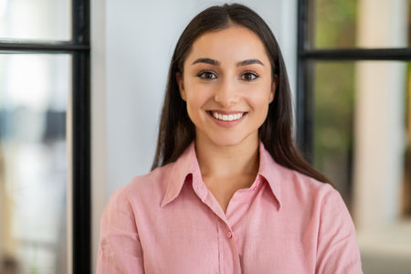 Headshot of positive young arab businesswoman manager in modern coworking officeの写真素材