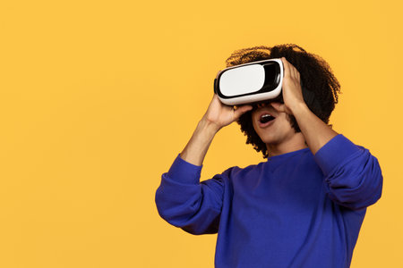 Young african american guy in casual using VR glasses