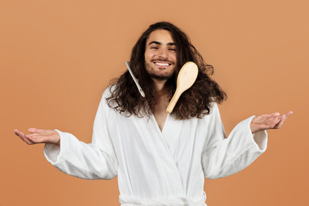 Guy Posing With Hairbrushes Stuck In Curly Hair Shrugging, Studioの写真素材
