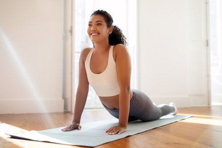 lady on mat bending back into yoga asana indoors