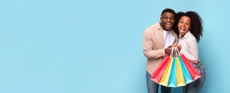Excited african american couple with shopping spree joy, panorama with copy spaceの写真素材