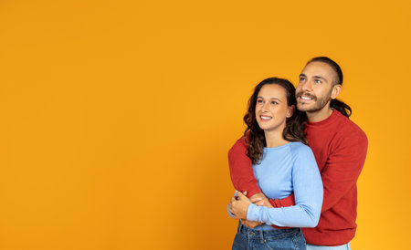 Beautiful young european couple hugging and looking at copy spaceの写真素材