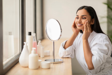 Portrait Of Attractive Happy Woman Looking At Mirror In Bathroomの写真素材