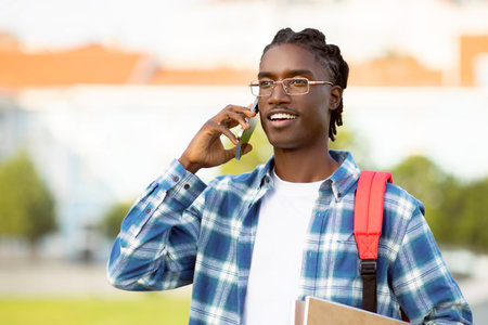 african american student guy talking on cell phone in parkの写真素材