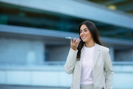 Arabic Businesswoman Using Voice Search Application On Phone Outdoorsの写真素材