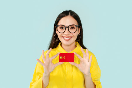 Cheerful brunette young woman showing credit card