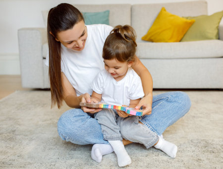 Mother And Little Daughter Checking New Toy While Playing Together At Home