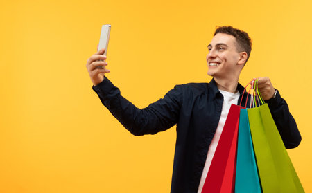 Stylish young man shopaholic taking selfie on phoneの写真素材