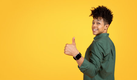 Cool young black guy showing thumb up gesture, copy spaceの写真素材