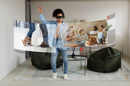 Tech-savvy young black woman connects with friends on picnic through virtual screen via VR headset at homeの写真素材