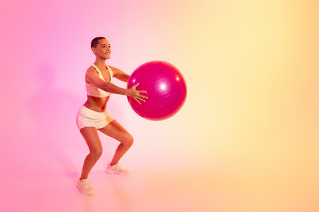 A young woman in sportswear performs a graceful yoga pose, showcasing tranquility and balanceの写真素材