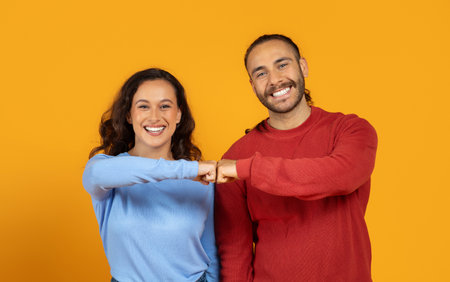 Portrait of positive man and woman doing fist bumpの写真素材