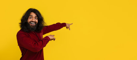 Emotional hindu guy pointing at copy space for advertisementの写真素材