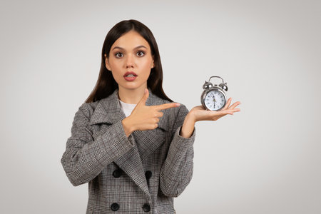 Businesswoman with clock, emphasizing time managementの写真素材
