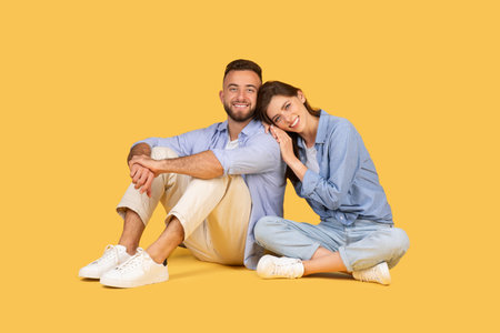 Relaxed couple sitting on floor, woman leaning on mans shoulderの写真素材
