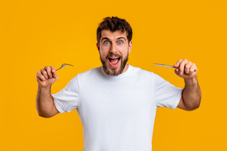 Emotional man holding knife and fork ready to eat, studioの写真素材