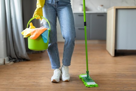Woman with bucket and mop ready for floor cleaning